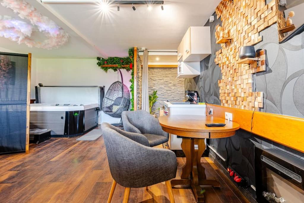 une cuisine avec une table et des chaises dans une pièce dans l'établissement Le 36/Espace bien-être privatif, à Bellevaux