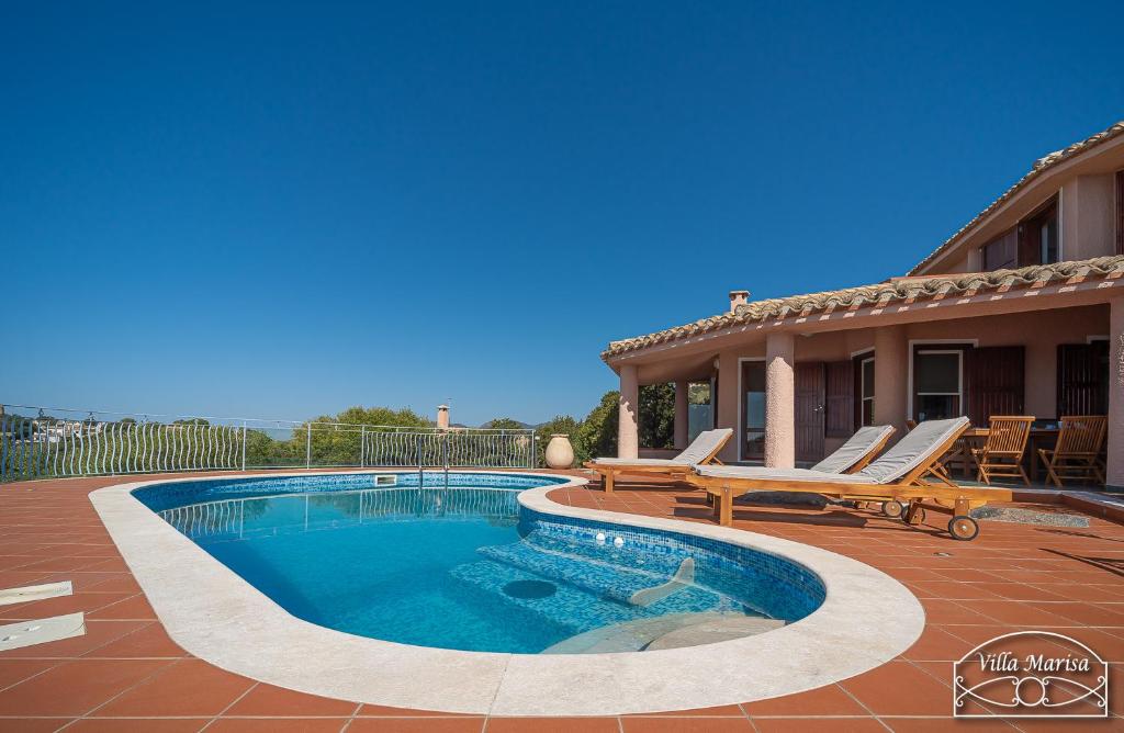 une piscine avec deux chaises et une maison dans l'établissement Villa Marisa, à Torre delle Stelle