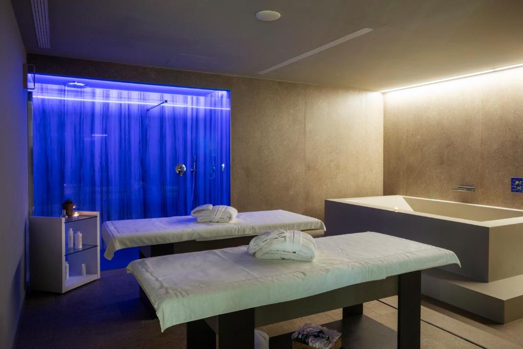 une salle de bain avec deux lits et une baignoire dans l'établissement Mangia's Torre Del Barone Resort & SPA, à Sciacca