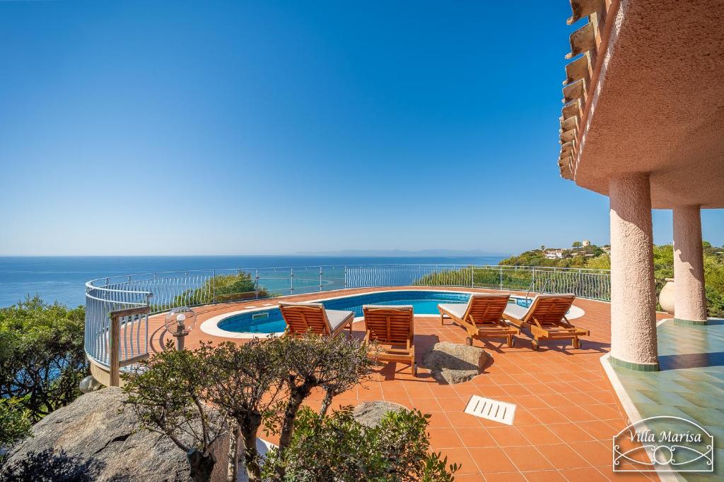 une terrasse avec des chaises, une piscine et l'océan dans l'établissement Villa Marisa, à Torre delle Stelle