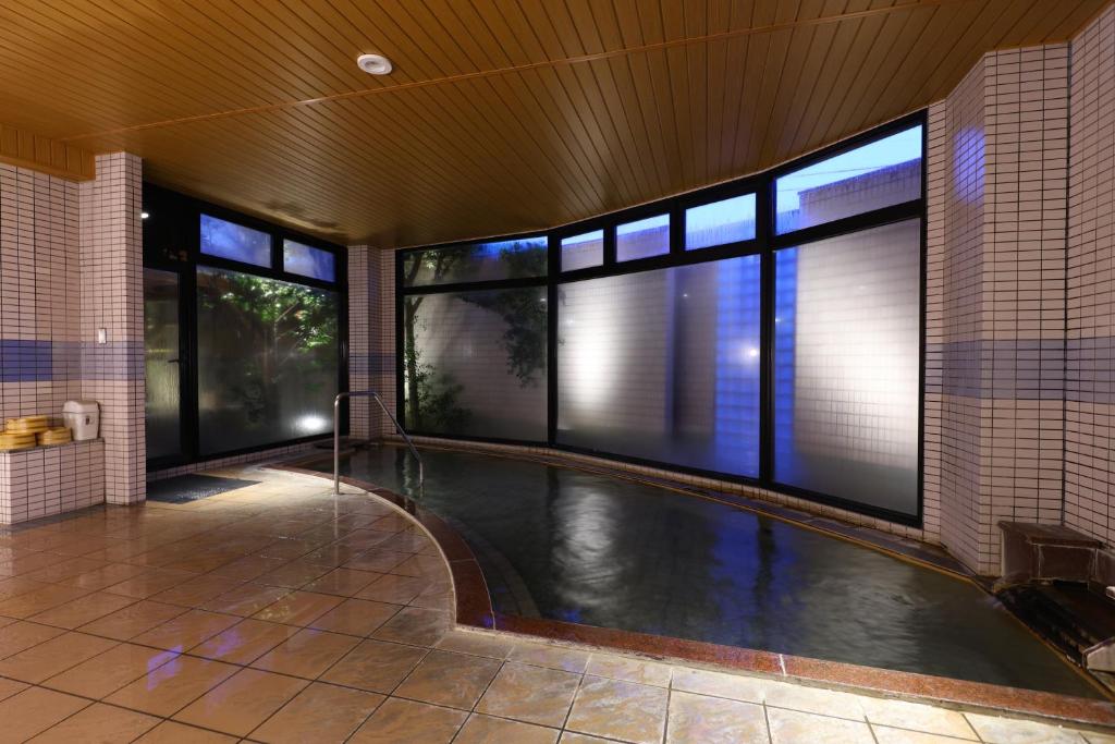 - une piscine intérieure dans un bâtiment avec fenêtres dans l'établissement Suwakoen, à Suwa