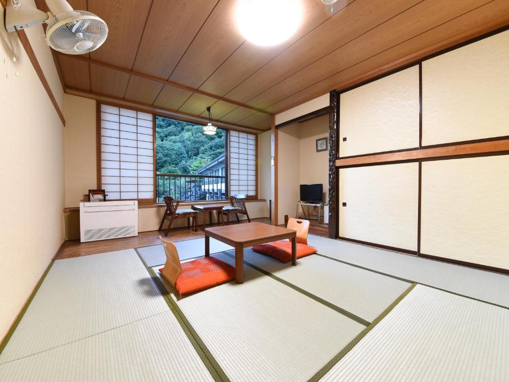 un salon avec une table et des chaises dans l'établissement Iwazonokan, à Minami Alps 33 autres photos