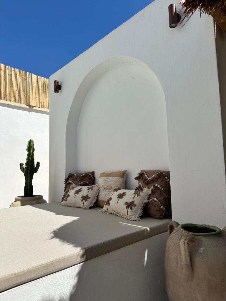 une chambre blanche avec un canapé et un cactus dans l'établissement Midi Pool Villa & SPA, à Veglie