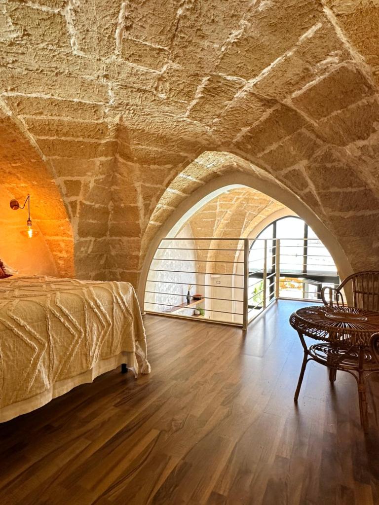 une chambre avec un lit et un mur en pierre dans l'établissement Midi Pool Villa & SPA, à Veglie 161 autres photos