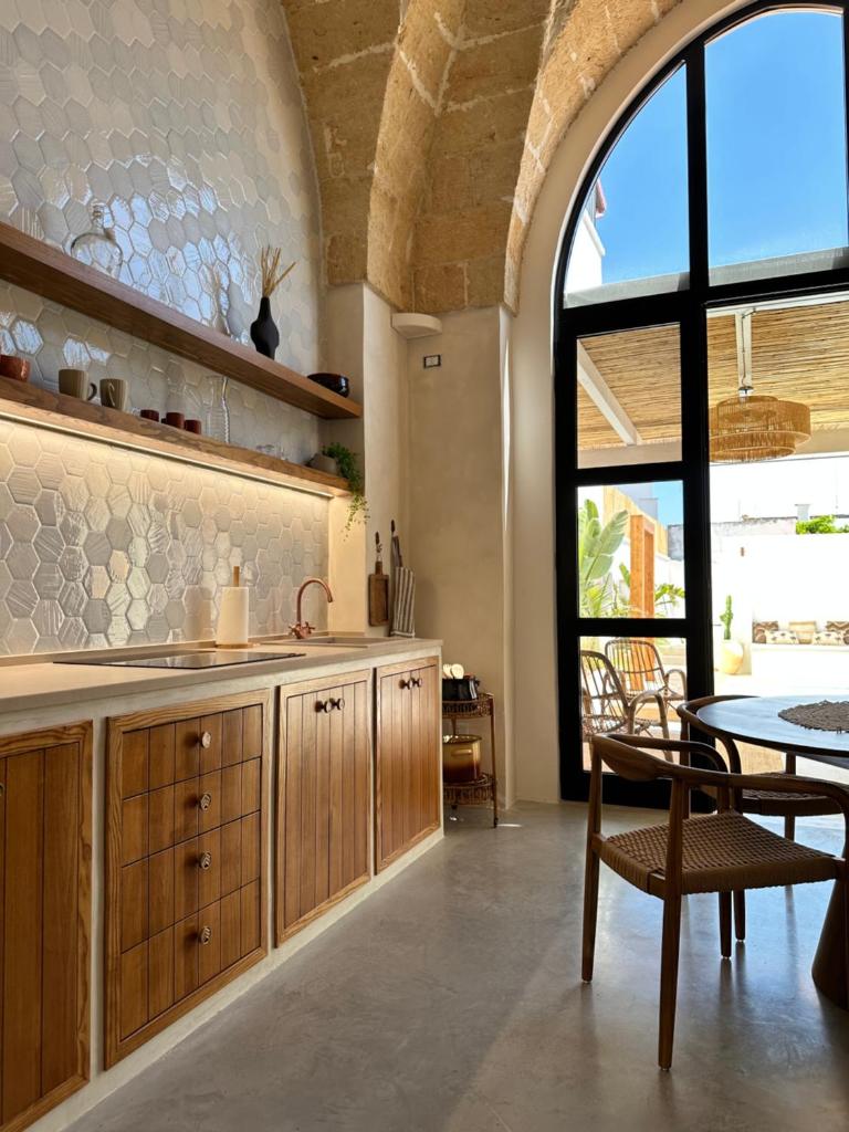 une cuisine avec évier et table ainsi qu'une salle à manger dans l'établissement Midi Pool Villa & SPA, à Veglie