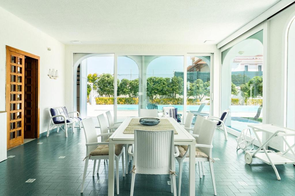 une salle à manger avec une table et des chaises blanches dans l'établissement Villa Mar Mar con piscina by Wonderful Italy, à Bari