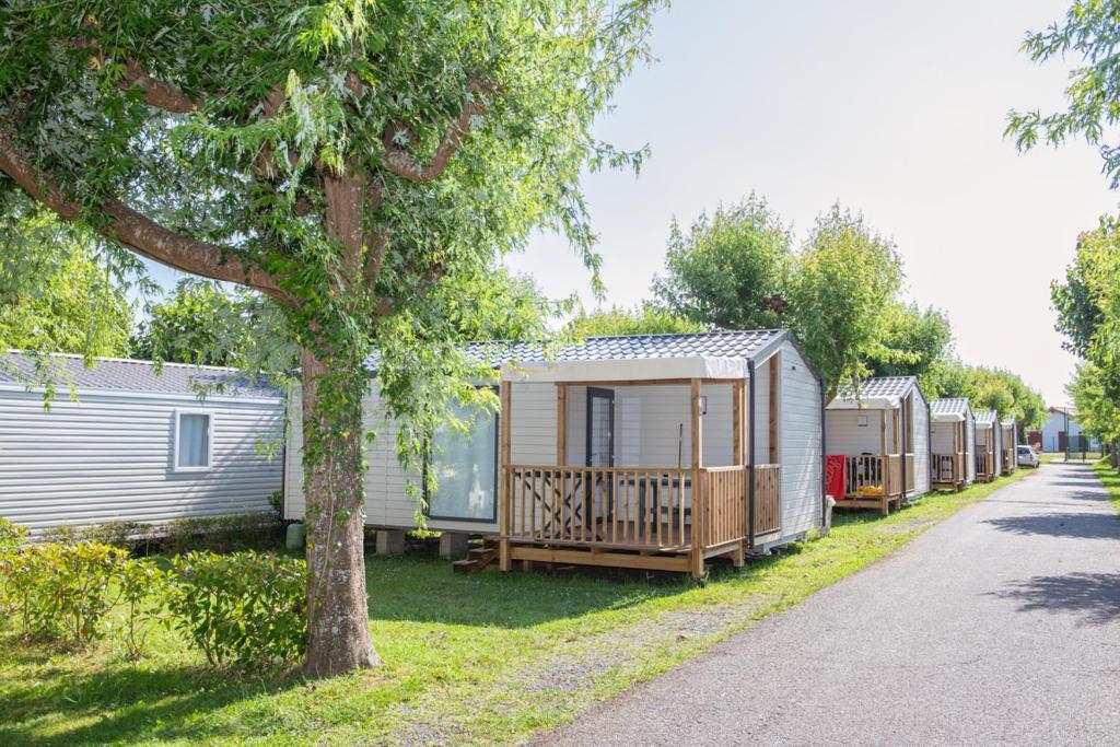 une rangée de mobile homes garés à côté d'une route dans l'établissement la ferme des 4 chenes, à Urt