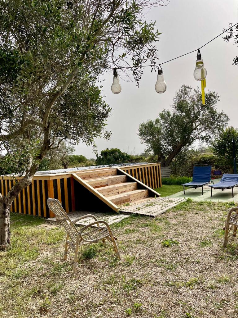 une maison en bois avec deux chaises et deux lumières dans l'établissement 19th century Trullo Raeda in the middle of nature, à Nardò