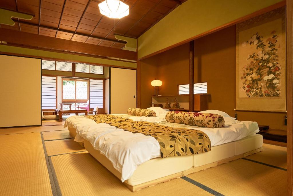 - une grande chambre avec un grand lit dans l'établissement Arifuku Onsen Yoshidaya, à Gotsu