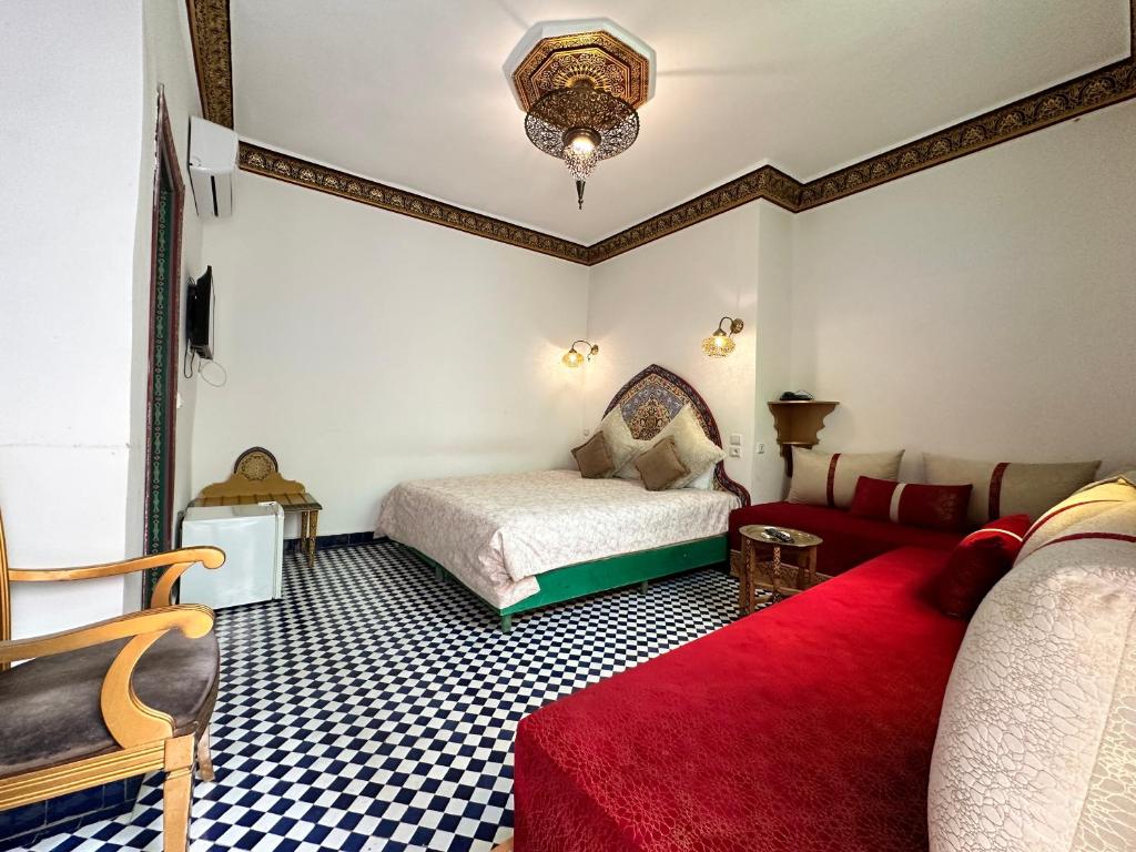 - une chambre avec un lit, un canapé et un tapis rouge dans l'établissement Riad Shama Fes, à Fès