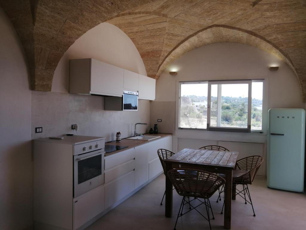 une cuisine avec une table et des chaises et une fenêtre dans l'établissement Casina Le Muse, à Marina di Pescoluse