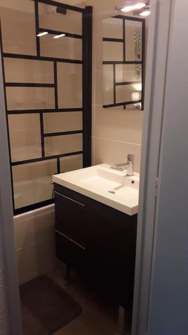 une salle de bain avec un lavabo et un miroir dans l'établissement Au Petit Conf'Orres, aux Orres 4 autres photos