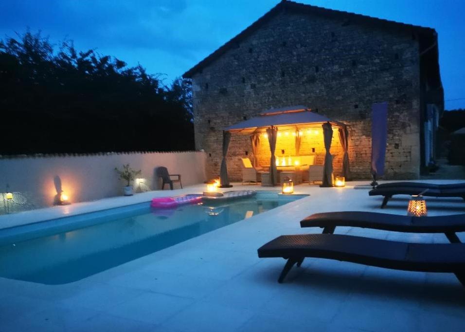 une piscine avec des chaises et un gazebo dans l'établissement Gite Petit Coin de Paradis, à Les Alleuds