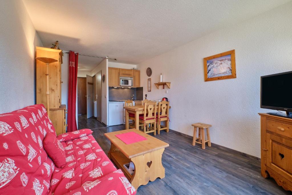 un salon avec un canapé rouge et une table dans l'établissement La montagne, à Les Deux Alpes