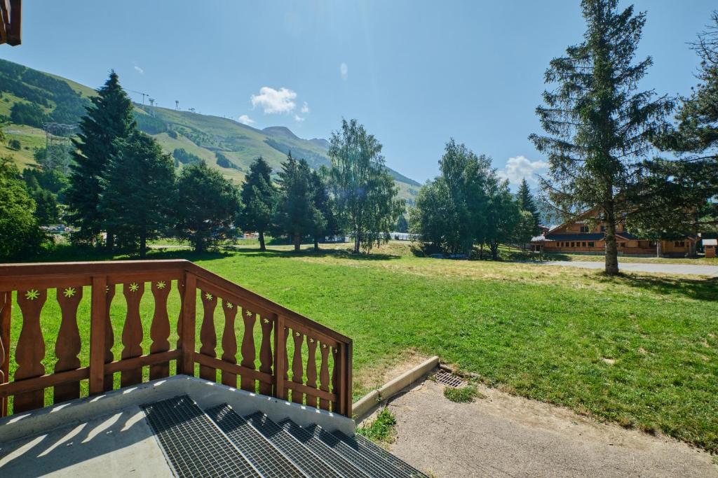 une terrasse en bois avec vue sur un champ dans l'établissement La montagne, à Les Deux Alpes