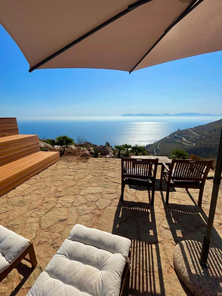 - une terrasse avec 2 bancs et un parasol dans l'établissement Casa di Cri, à San Vito Lo Capo