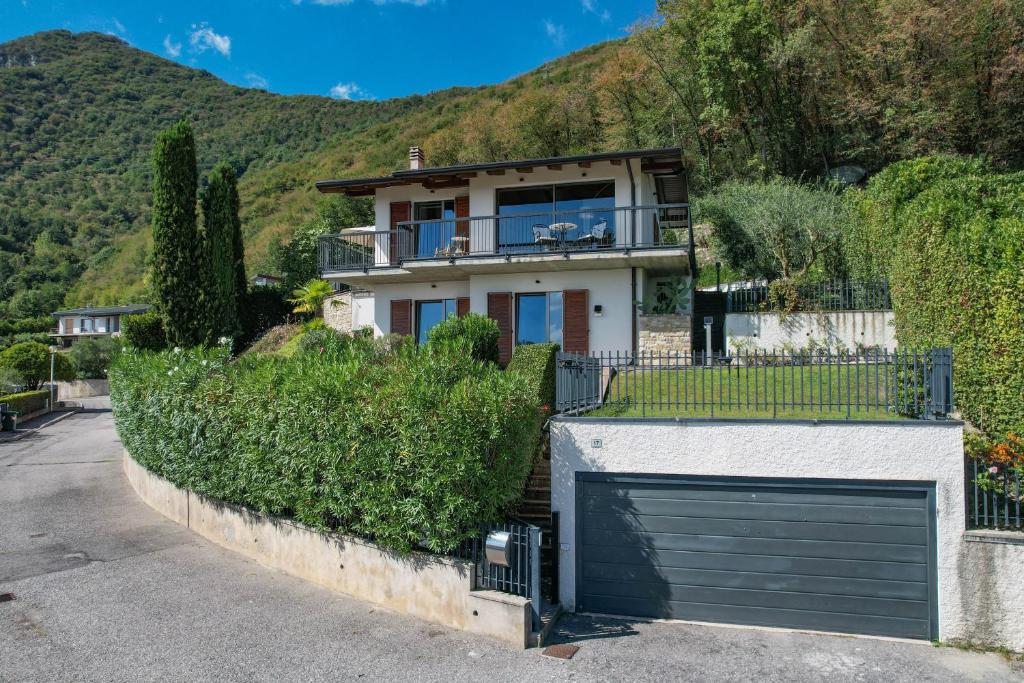 une maison avec un garage et une montagne dans l'établissement Villa Rondine - Villa mit beheiztem Pool, à Salò