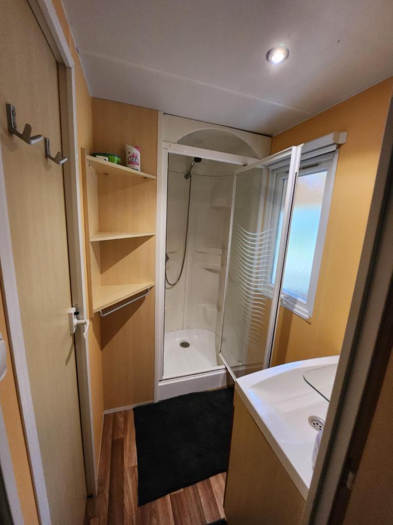 La petite salle de bains est pourvue d'une douche et d'un lavabo. dans l'établissement Le paradis du mobilhome, à Saint-Chéron