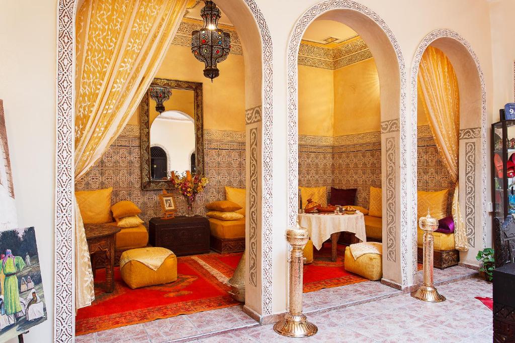 un salon avec une table et des chaises dans une pièce dans l'établissement Riad La Kahana, à Marrakech