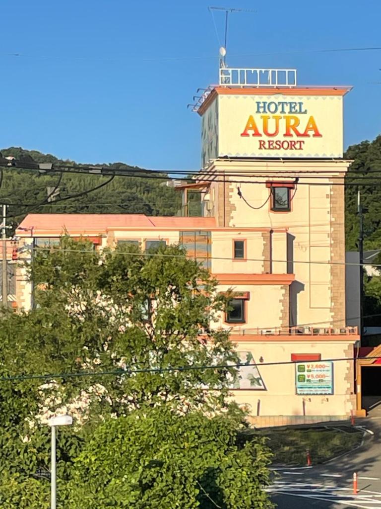 un hôtel auvergnat avec une enseigne au sommet d'un immeuble dans l'établissement オーラリゾート四條畷, à Shijonawate