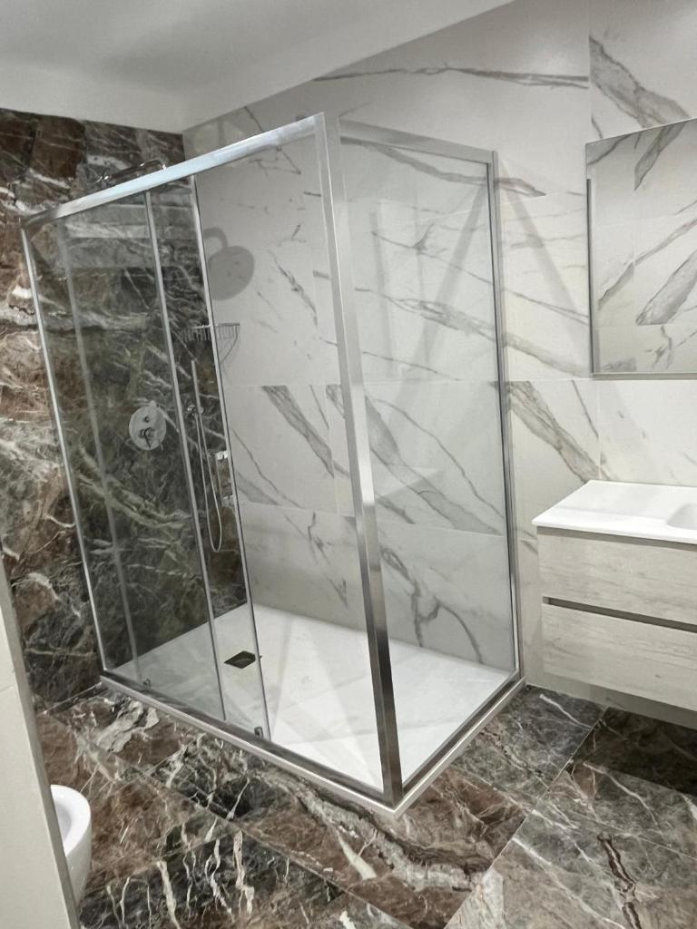 une douche avec une cabine en verre dans une salle de bain dans l'établissement Hotel Paladini, à Porto Cesareo