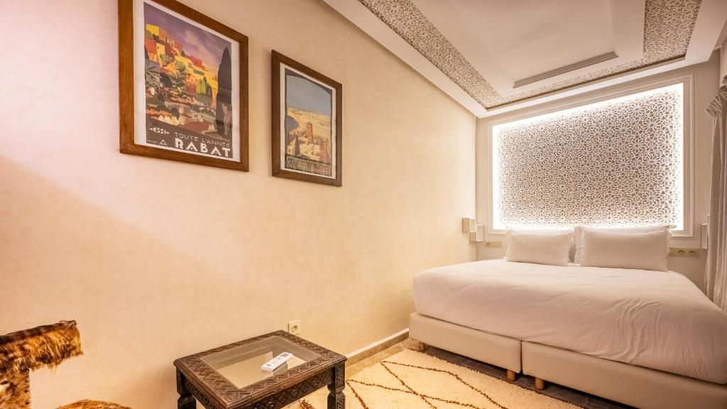 une chambre avec un lit, une fenêtre et une table dans l'établissement Riad Luxe Nomade Marrakech & Spa, à Marrakech