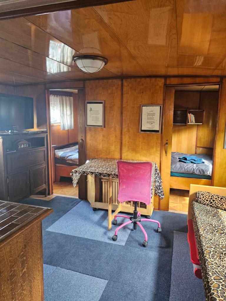 une pièce avec une table et une chaise dans un bateau dans l'établissement St Christopher, à Creil