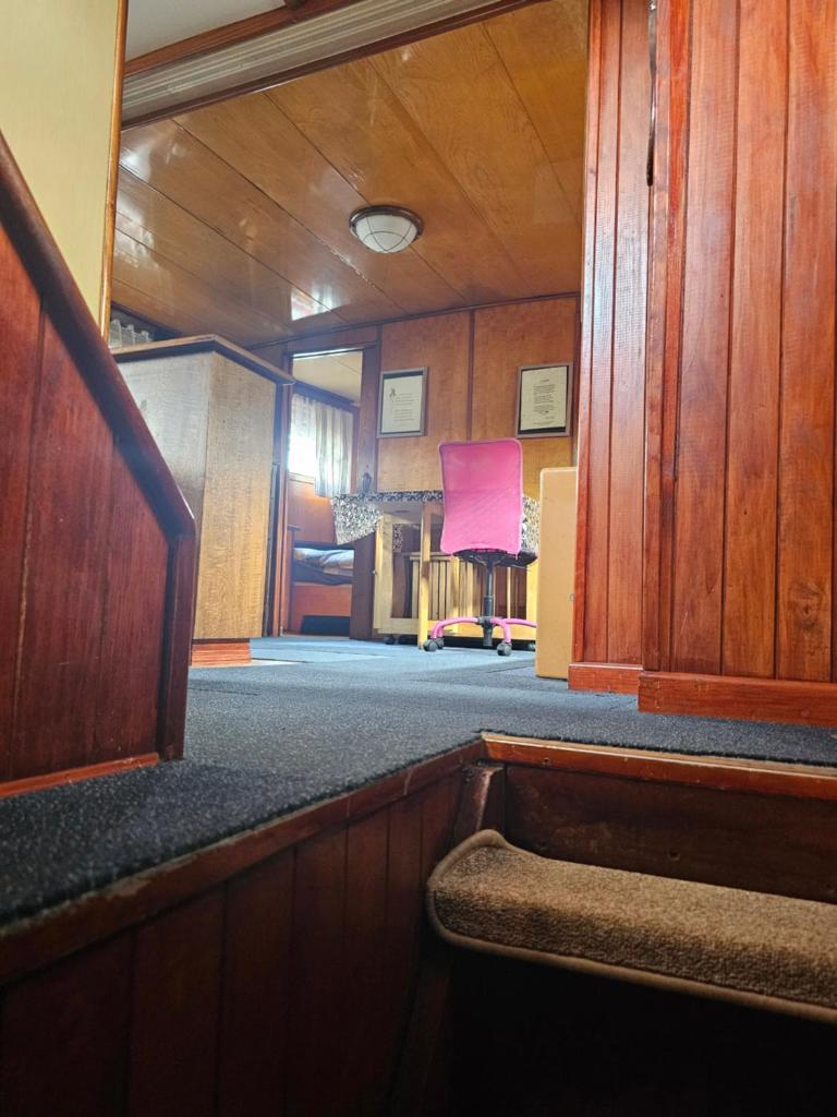 une pièce vide avec une chaise rose dans une pièce dans l'établissement St Christopher, à Creil