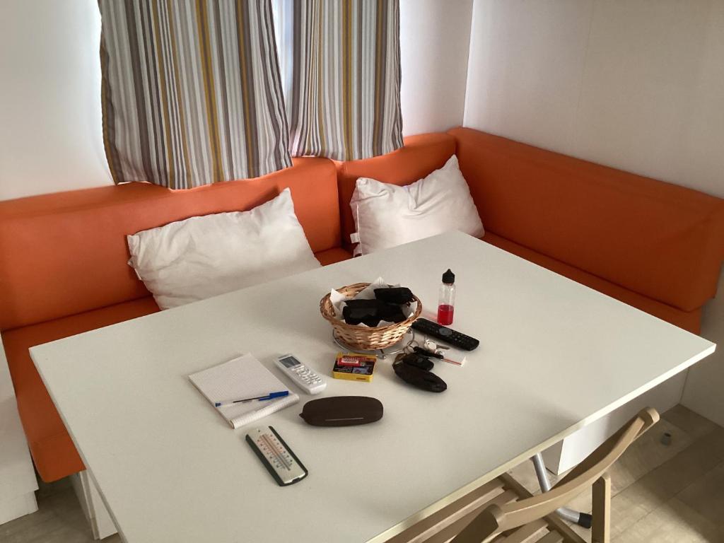 - un canapé orange avec une table blanche avec des sèche-cheveux dans l'établissement Mobile home 3 chambres Camping Flower Odalys, à Longeville-sur-Mer 10 autres photos