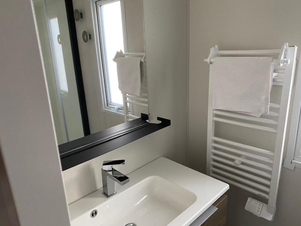 une salle de bain blanche avec un lavabo et un miroir dans l'établissement Segur 9, à Saint-Raphaël