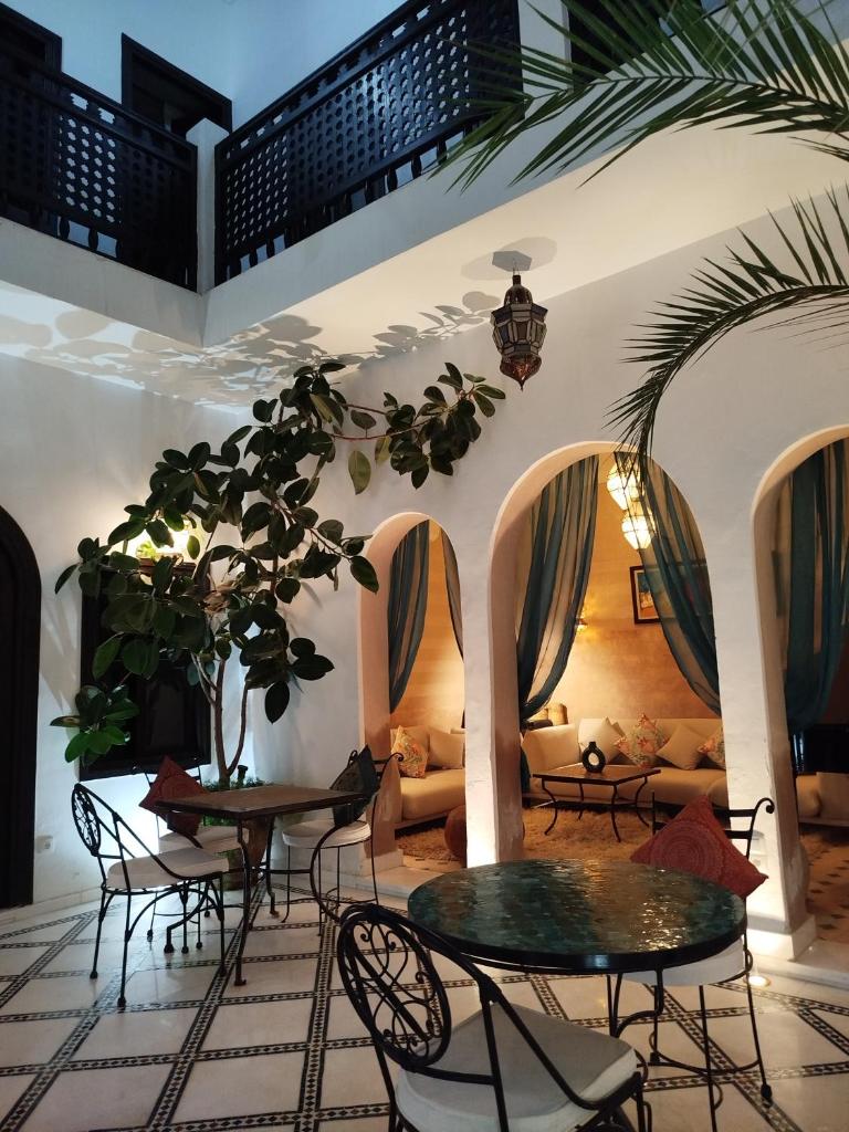 - un salon avec des tables, des chaises et un canapé dans l'établissement Riad Les Trois Mages, à Marrakech