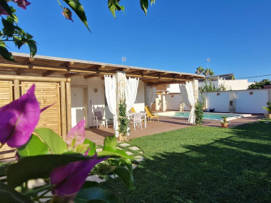 une cour avec une pergola en bois et une piscine dans l'établissement Casa Valerio, à Conversano