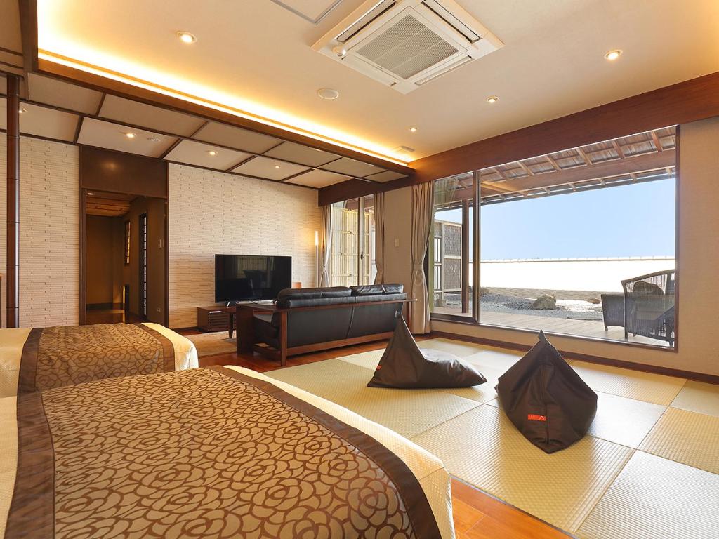 une chambre d'hôtel avec deux lits et une grande fenêtre dans l'établissement Arima Onsen Taketoritei Maruyama, à Kobe