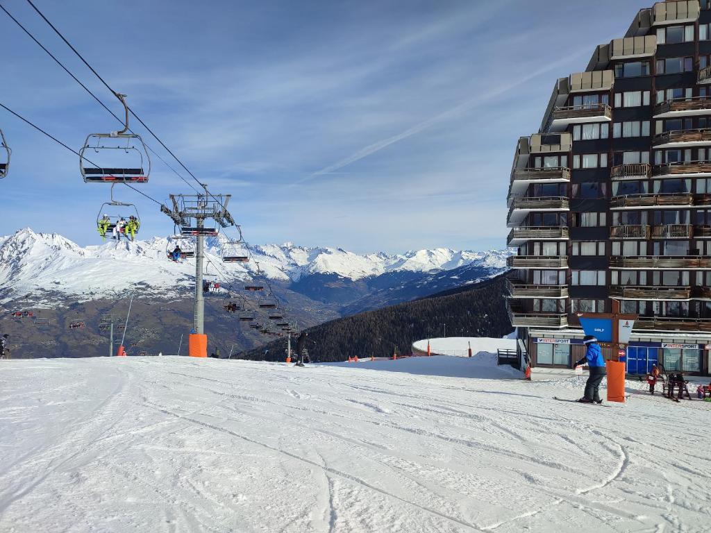 une remontée mécanique avec une personne debout sur une piste enneigée dans l'établissement Studio Cosy 2100m pied des pistes-Direct to SKI slopes-SKI in SKI out-LA PLAGNE AIME 2000, à Aime La Plagne