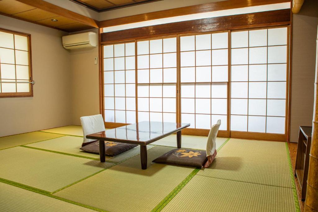 une chambre avec une table et une chaise devant une fenêtre dans l'établissement Shoji Lake Hotel, à Fujikawaguchiko