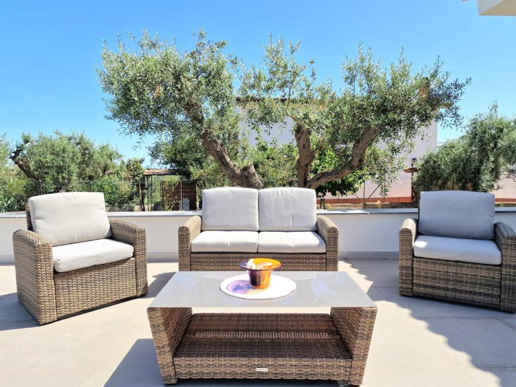 trois chaises et une table basse sur une terrasse dans l'établissement Villa Valentina, à Altavilla Milicia