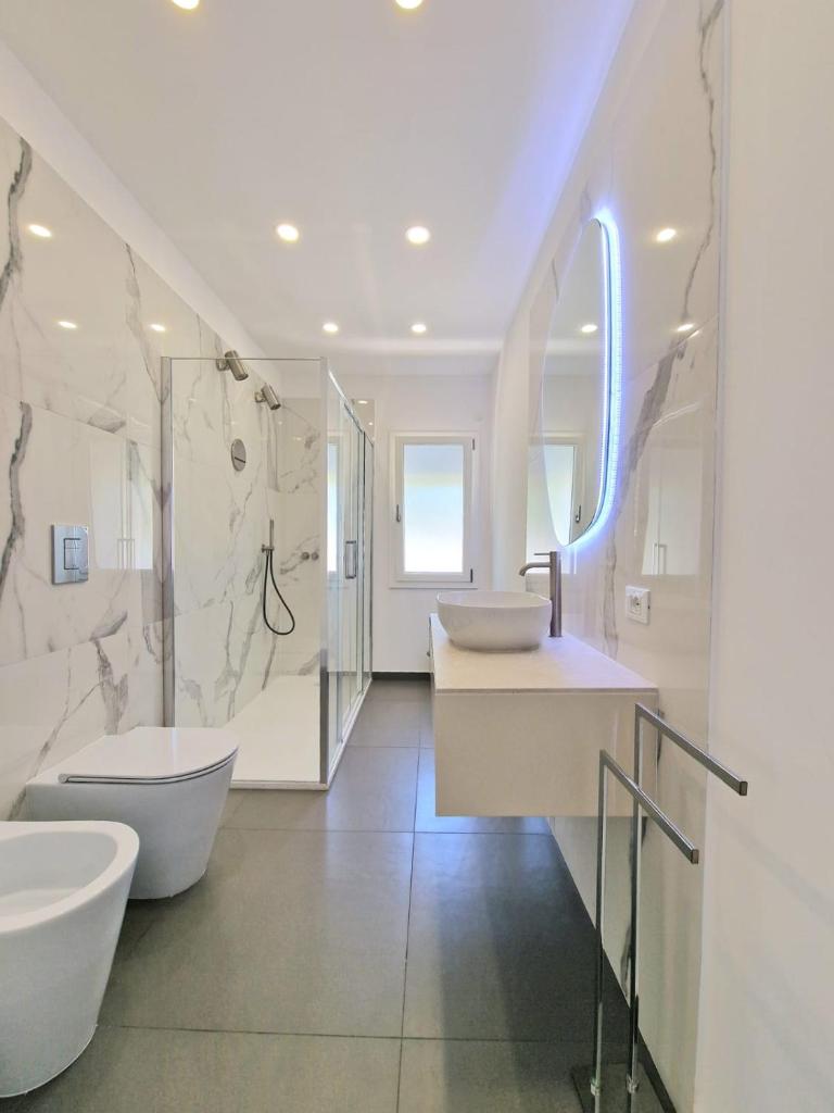 La salle de bains blanche est pourvue de 2 lavabos et d'une baignoire. dans l'établissement Villa Valentina, à Altavilla Milicia