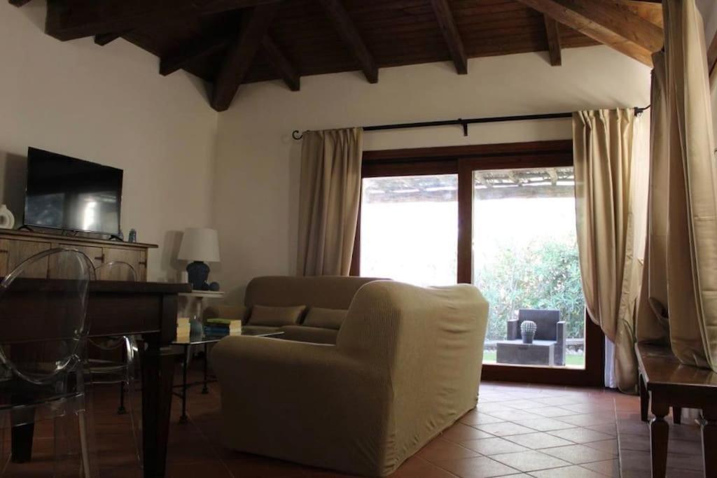 un salon avec un canapé, une table et une fenêtre dans l'établissement Villa Nina - Lussuosa Villa con piscina privata a Stintino, à Cuile Pazzoni