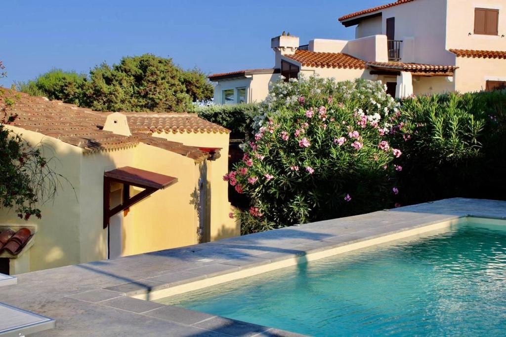 - une piscine dans une cour à côté d'un bâtiment dans l'établissement Villa Nina - Lussuosa Villa con piscina privata a Stintino, à Cuile Pazzoni