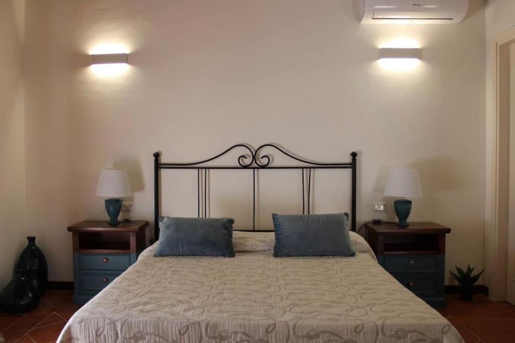 - une chambre avec un grand lit et 2 oreillers bleus dans l'établissement Villa Nina - Lussuosa Villa con piscina privata a Stintino, à Cuile Pazzoni