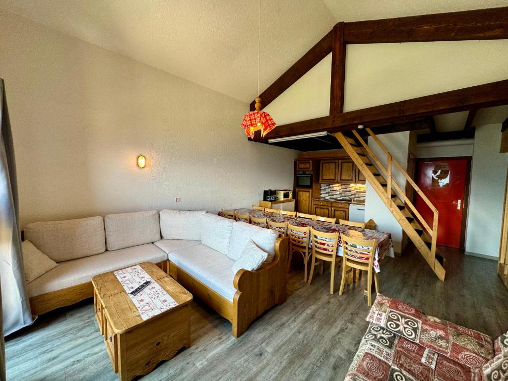 un salon avec un canapé et une salle à manger dans l'établissement Le Chalet de Bisanne, aux Saisies