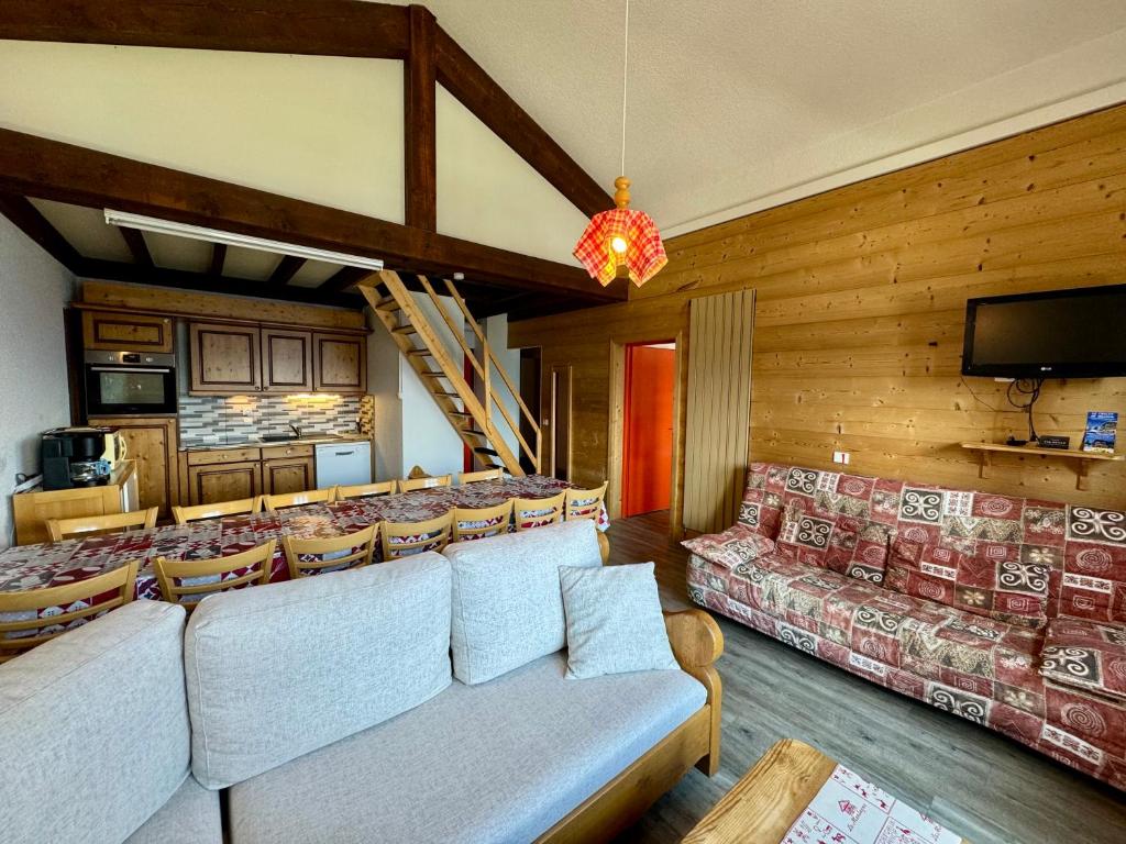 un salon avec des canapés et une télévision à écran plat dans l'établissement Le Chalet de Bisanne, aux Saisies