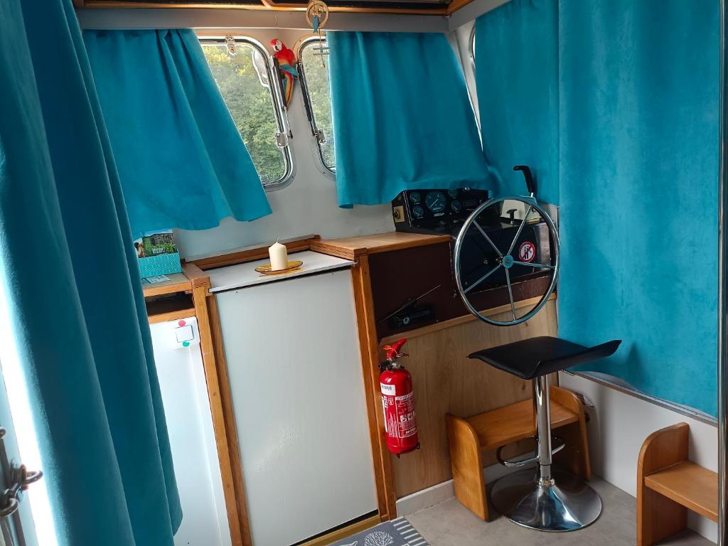 - une petite cuisine dans une caravane dotée de rideaux bleus dans l'établissement Kernou Tala Lila, à Mareuil-sur-Ay