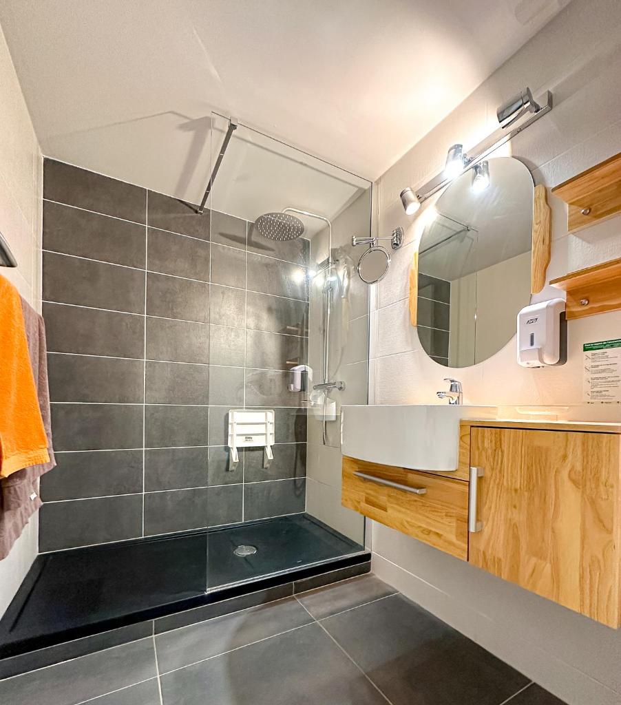 une salle de bain avec une douche avec un lavabo et un miroir dans l'établissement Auberge Alpina, à Gréolières