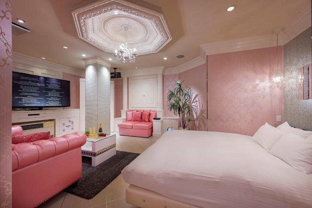 une chambre avec un grand lit blanc et des meubles roses dans l'établissement ホテルディオールセブン郡山, à Koriyama 60 autres photos