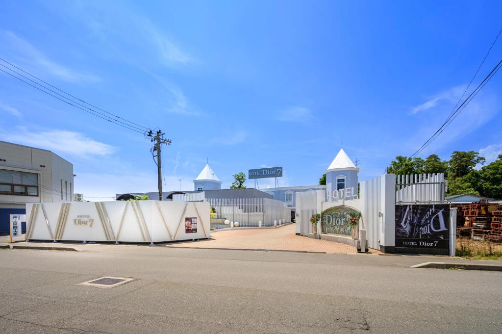 une rue avec des bâtiments blancs et une rue avec une route dans l'établissement ホテルディオールセブン郡山, à Koriyama