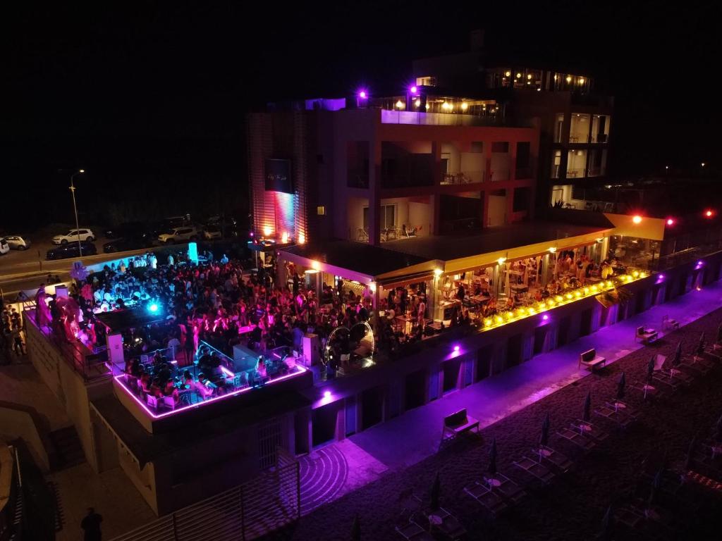une foule de personnes debout devant un bâtiment la nuit dans l'établissement Il Fogliano Hotel New Life, à Latina