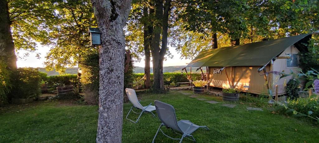 une tente et deux chaises devant un arbre dans l'établissement Tente lodge la Flavignienne, à Flavigny-sur-Ozerain