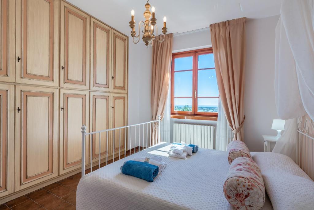 une chambre avec un berceau avec des oreillers bleus et une fenêtre dans l'établissement Le Lanterne - Villa vista mare, à Massarosa