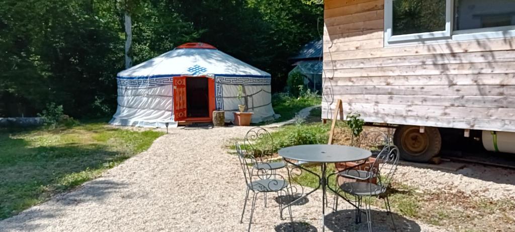 - une table et des chaises devant une yourte dans l'établissement Yourte en pleine nature, à Dampierre